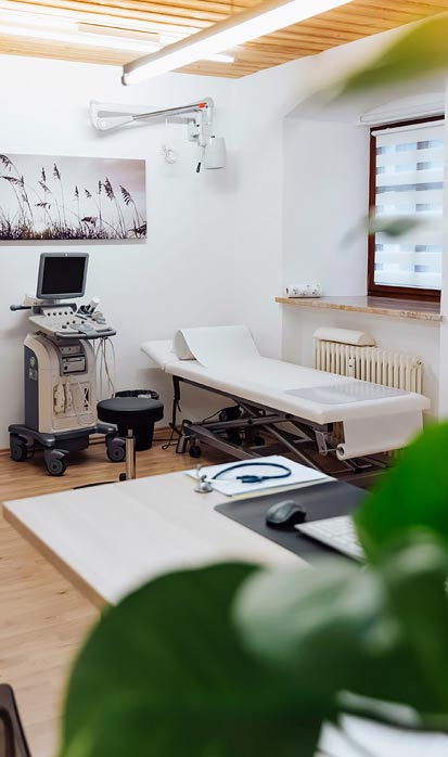 Praxis Dr. Dachauer Behandlungszimmer mit Ultraschallgerät und Liege
